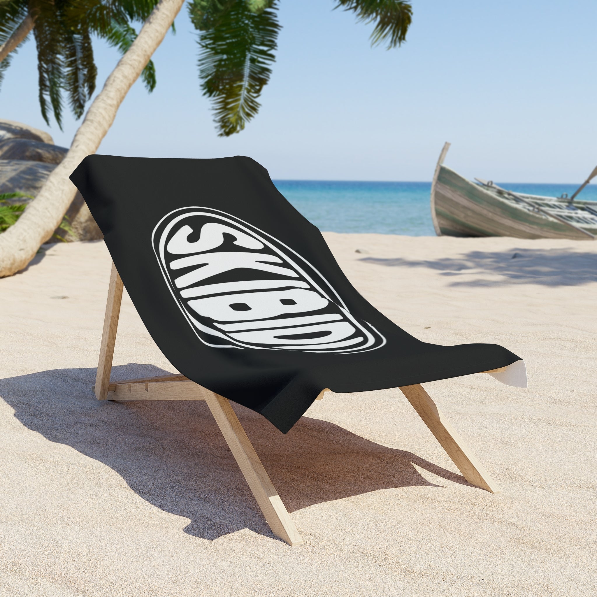 Beach towel in black and white featuring the SKIBIDI oval emblem on chair at beach